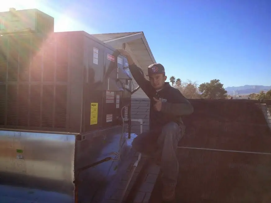 HVAC technician performing HVAC Inspection on a rooftop unit in Albertville